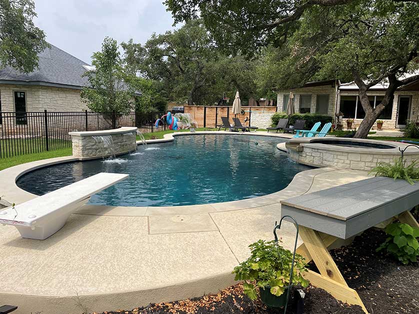 Pool with diving board in Texas backyard.