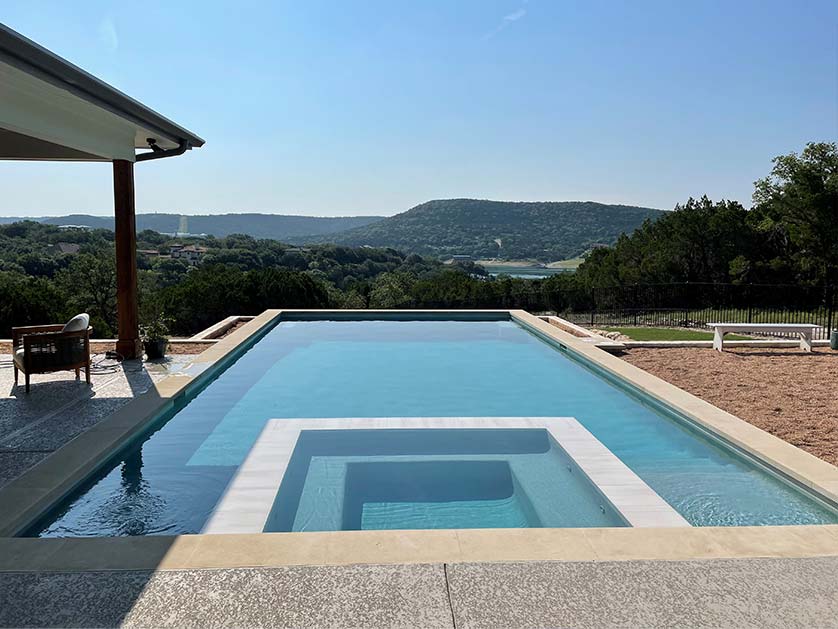Gorgeous modern geometric pool with built-in hot tub. Patio with pergola adjacent to the pool, all overlooking a scenic overlook in this very special Texas property.